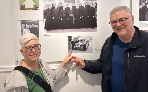 Nicole et Claude montrent une photo de Réal Blain, PMÉ a l’exposition du centenaire de la SMÉ à Pont-Viau